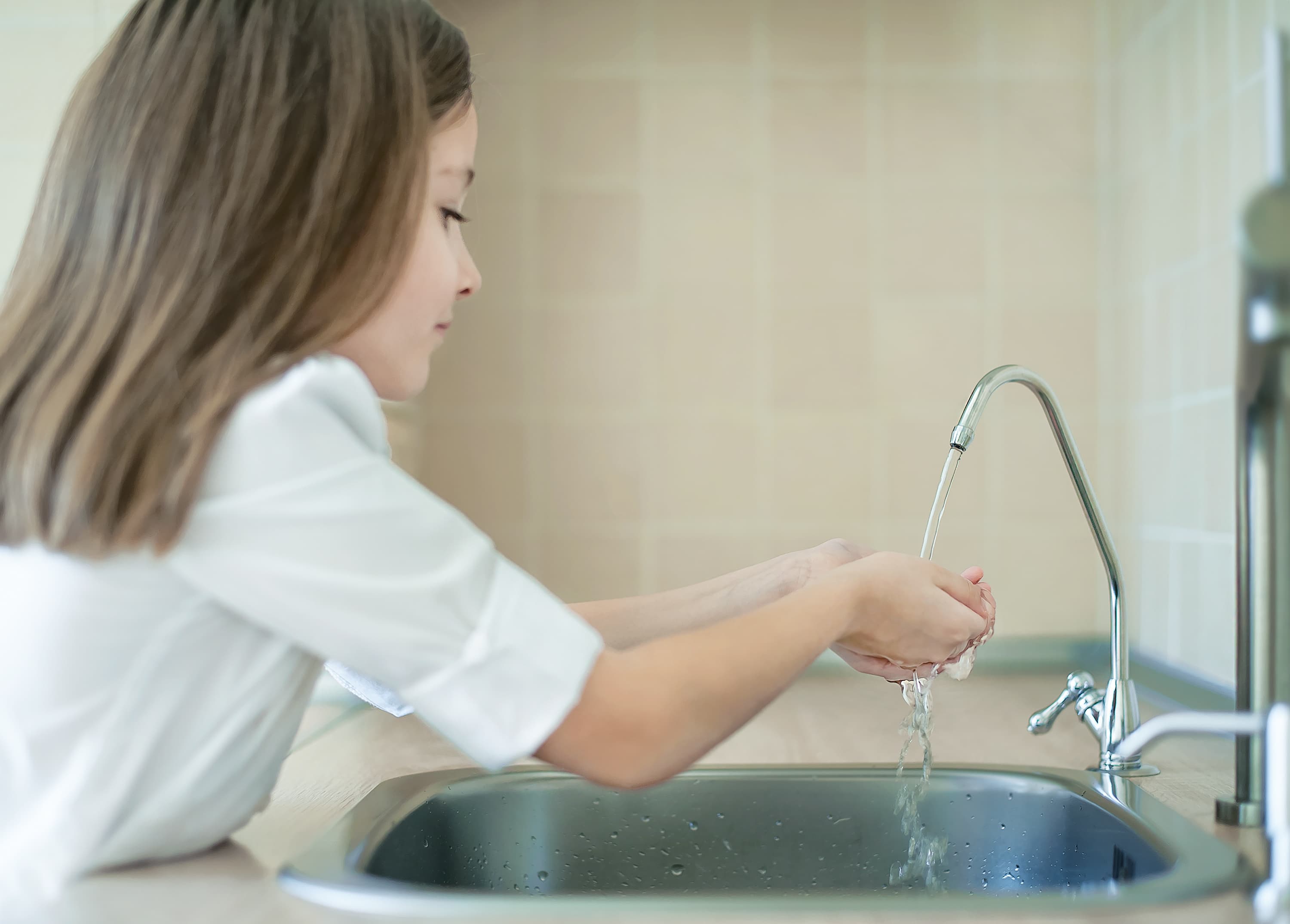A child washing hands in chlorine-free water after Intiwater install
